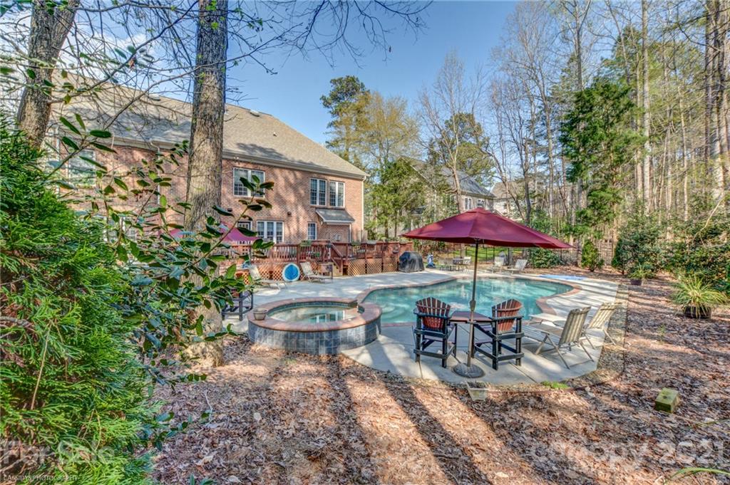 2678 Landing Pointe Drive Clover, SC 29710 - Photo 41 of 48 a view of a patio with chairs and table under an umbrella with large trees