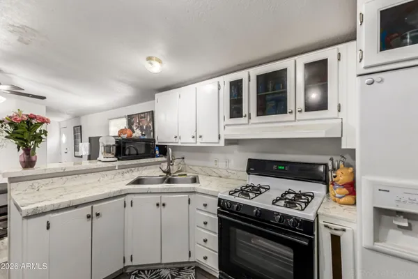 a kitchen with granite countertop a stove sink and cabinets