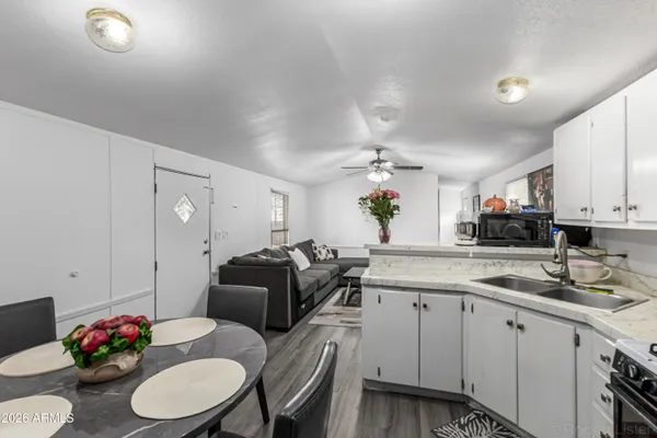 a kitchen with granite countertop a white cabinets and chairs