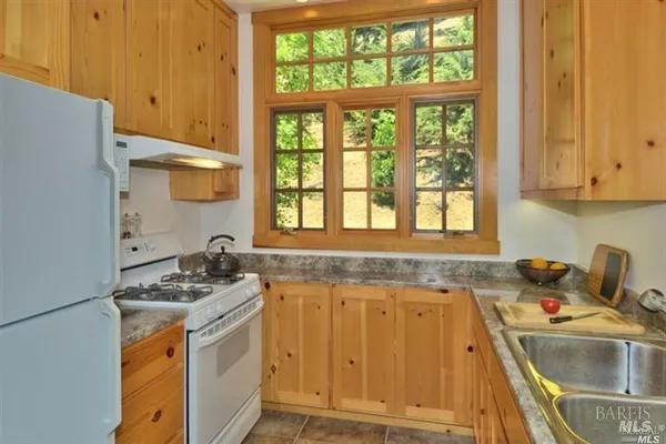 a kitchen with a sink a stove and cabinets