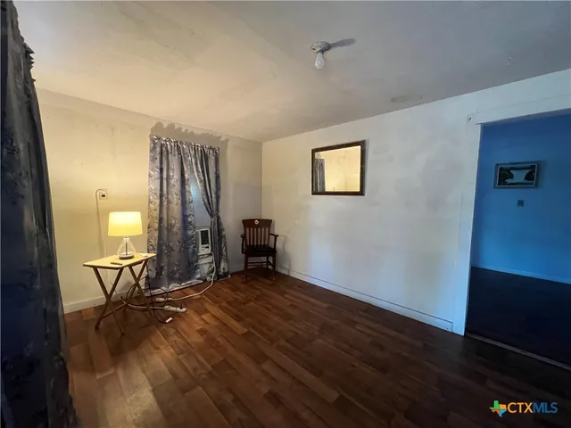 a view of a room with wooden floor and furniture