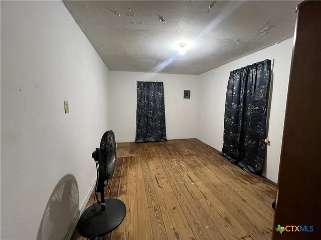 a bed room with a bed and a wooden floor