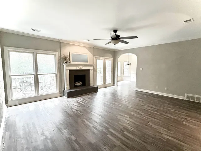 a spacious bedroom with a bed and a flat screen tv