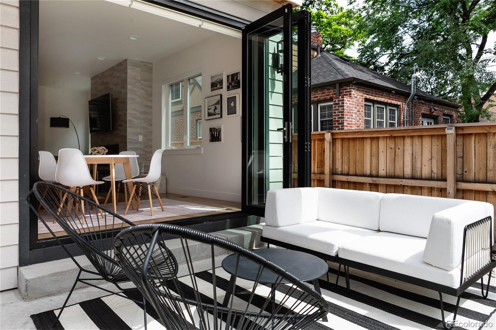2645 Eudora Street Denver, CO 80207 - Photo 13 of 40 a view of a patio with couches table and chairs with wooden floor and fence