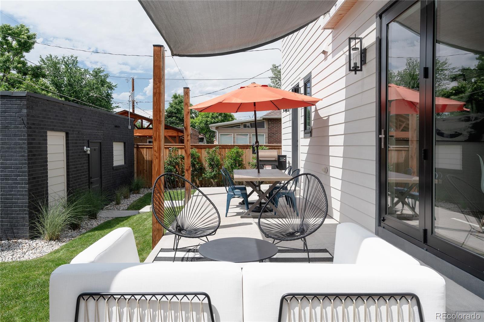 2645 Eudora Street Denver, CO 80207 - Photo 14 of 40 a view of a patio with a dining table and chairs under an umbrella