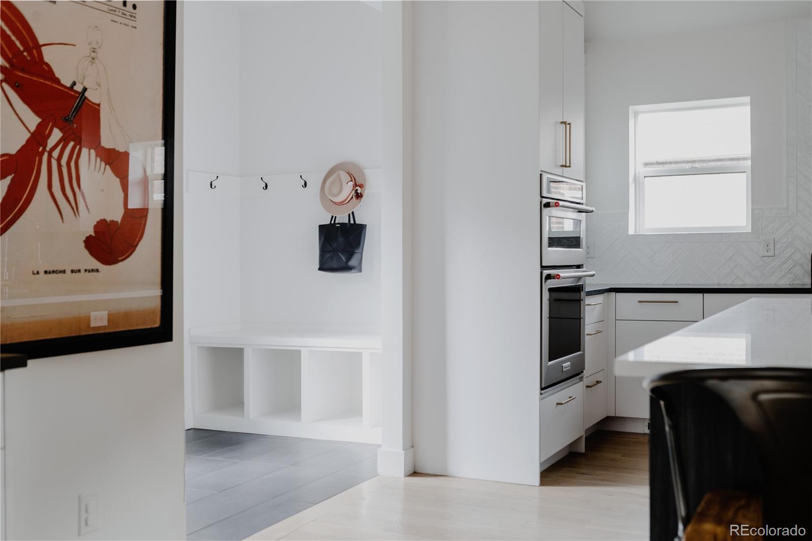 2645 Eudora Street Denver, CO 80207 - Photo 16 of 40 a hallway with a white cabinets and wooden floor