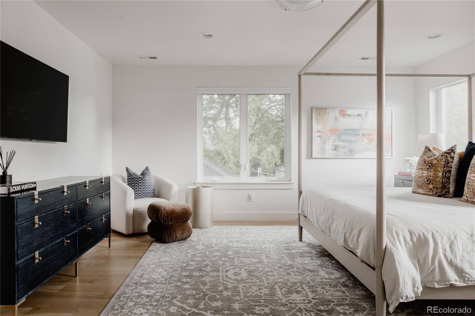 2645 Eudora Street Denver, CO 80207 - Photo 23 of 40 a bedroom with furniture and a flat screen tv