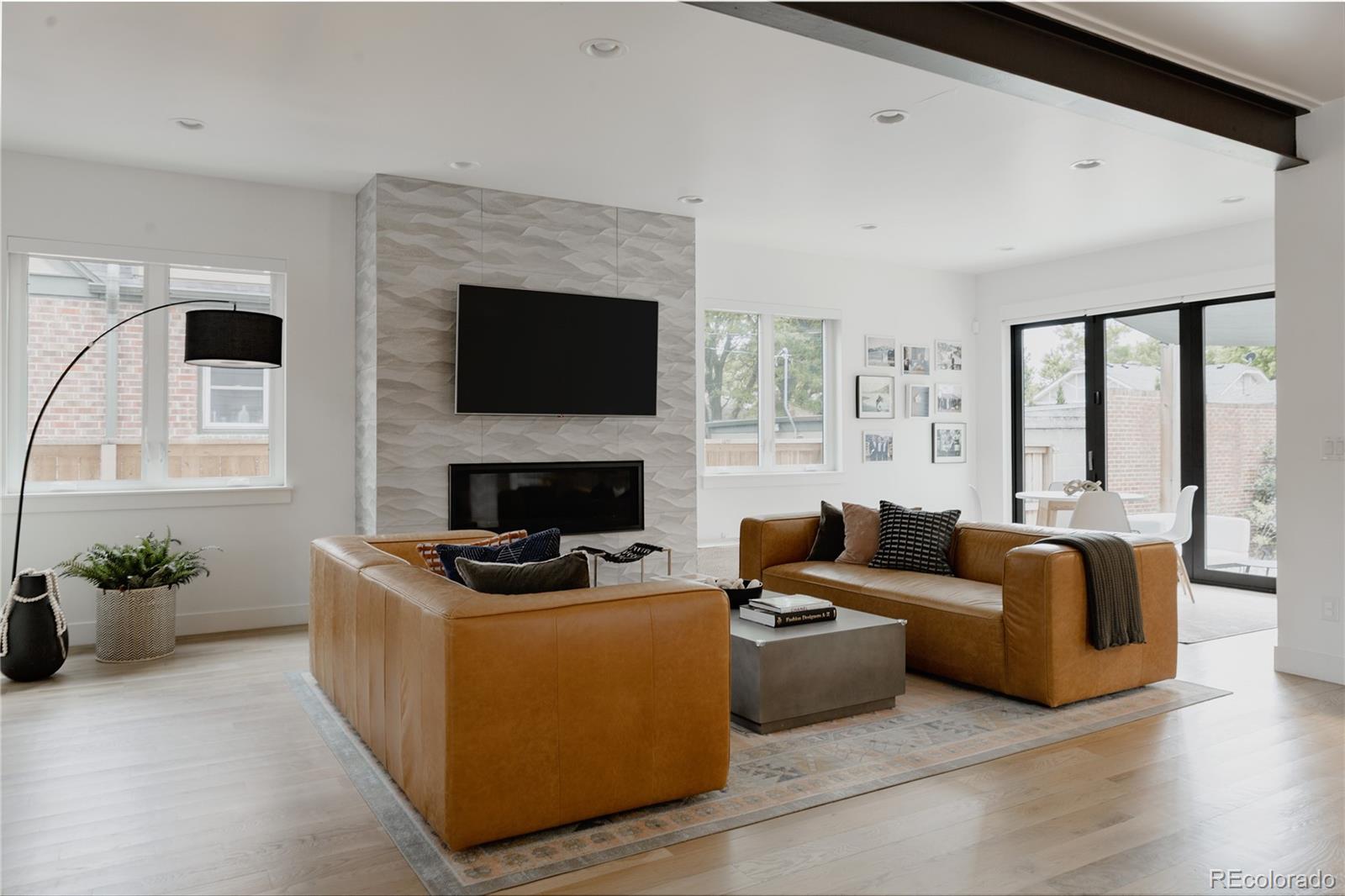 2645 Eudora Street Denver, CO 80207 - Photo 7 of 40 a living room with furniture flat screen tv and a fireplace