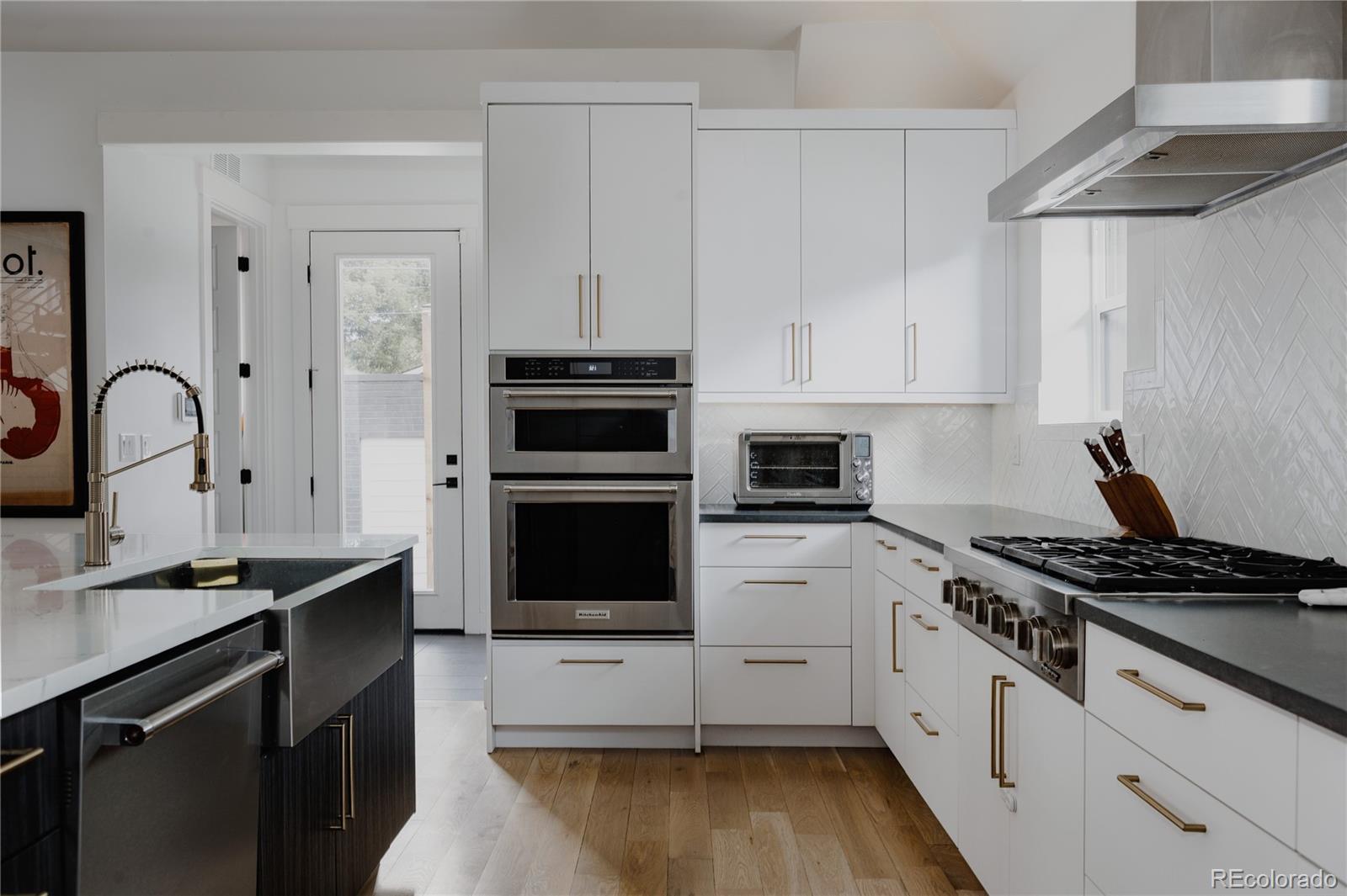 2645 Eudora Street Denver, CO 80207 - Photo 8 of 40 a kitchen with granite countertop a stove a sink and a microwave