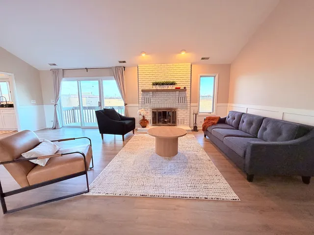 a living room with furniture fireplace and a large window