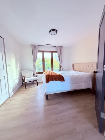 a bedroom with a bed and a large window