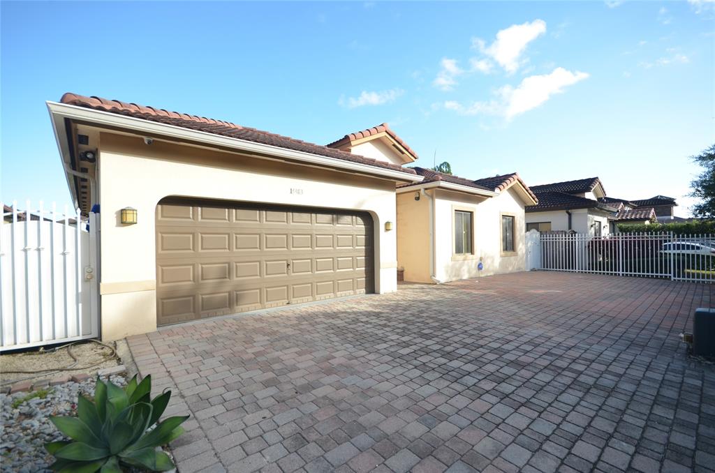 14483 Southwest 13th Terrace Miami, FL 33184 - Photo 3 of 27 a view of house with garage and small yard