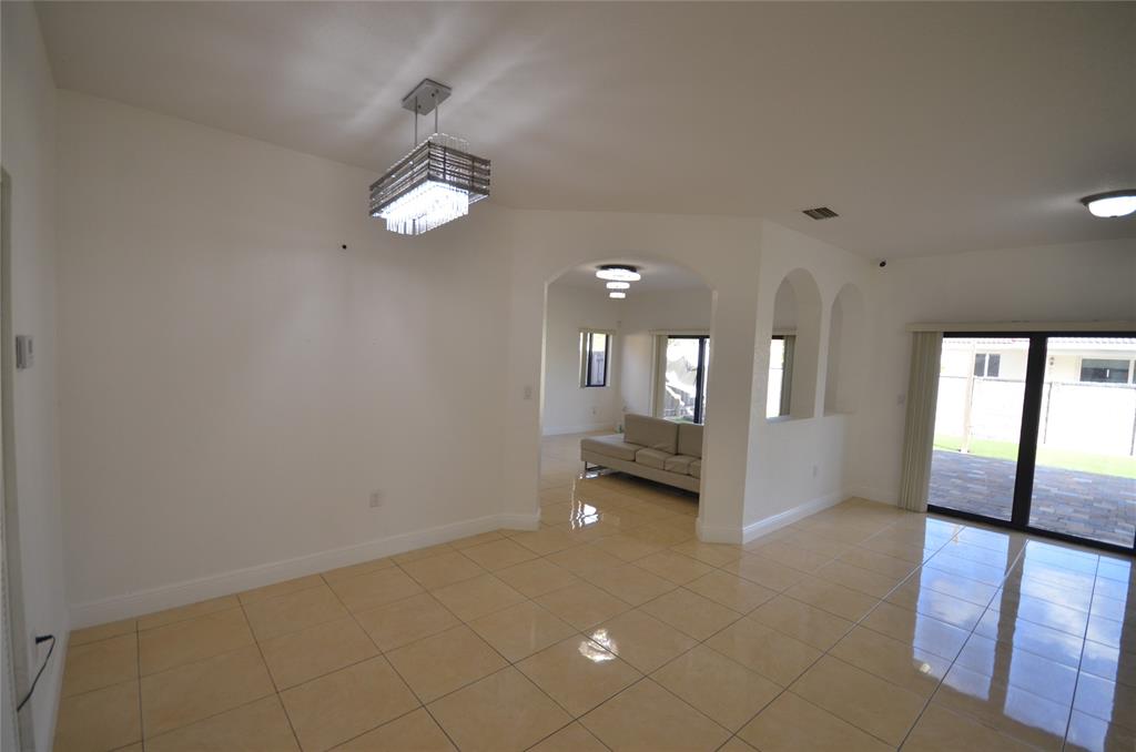 14483 Southwest 13th Terrace Miami, FL 33184 - Photo 5 of 27 wooden floor in an empty room with a window