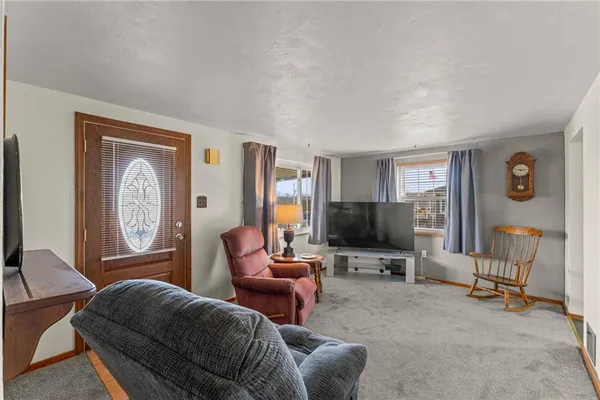 a living room with furniture a flat screen tv and a window