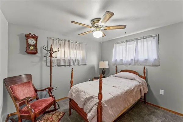 a bedroom with a bed a chair and a chandelier