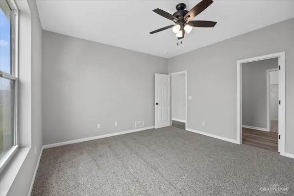 a view of a room with a ceiling fan and a ceiling fan