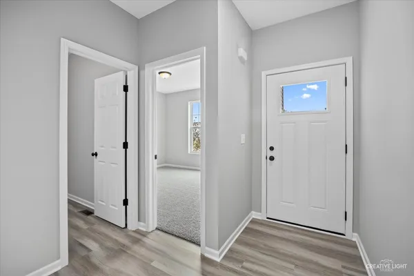 a view of a hallway with wooden floor and closet