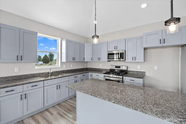 a kitchen with stainless steel appliances granite countertop a sink stove and refrigerator
