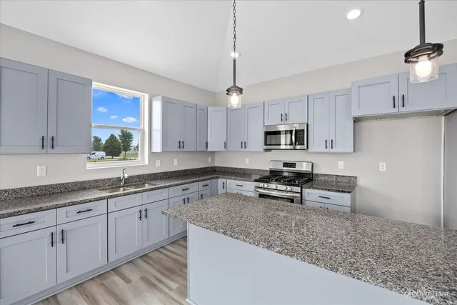 a kitchen with stainless steel appliances granite countertop a sink stove and refrigerator