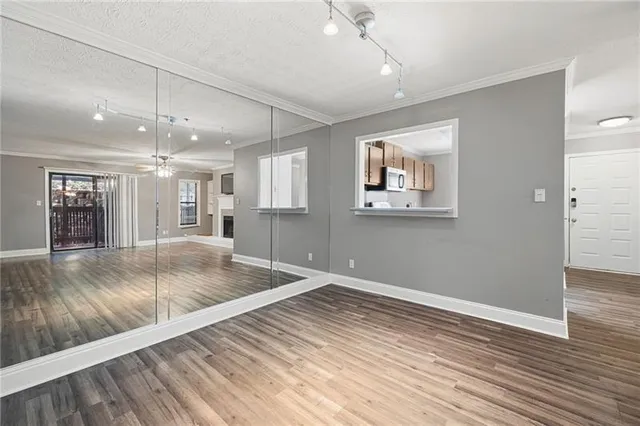 an empty room with wooden floor and windows