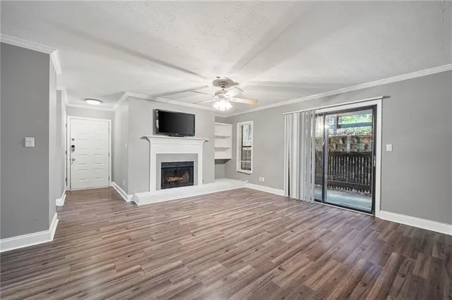 wooden floor fireplace and windows in an empty room