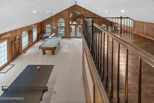 a living room with pool table and windows