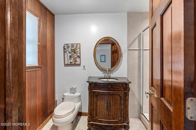 a bathroom with a toilet a sink a mirror and a window