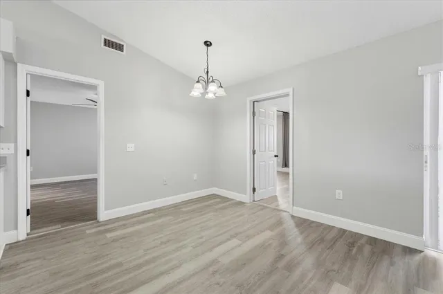 an empty room with wooden floor and mirror