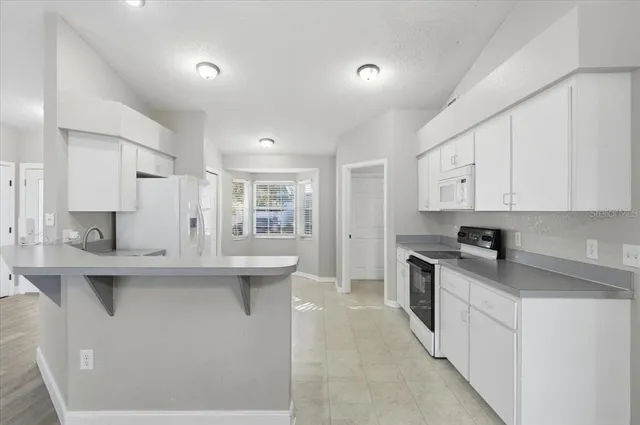a kitchen with stainless steel appliances granite countertop a sink stove and cabinets