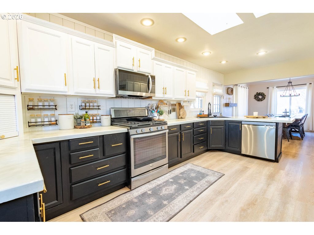 2703 North Spruce Street La Grande, OR 97850 - Photo 10 of 37 a kitchen with stainless steel appliances kitchen island granite countertop a sink counter space and a window