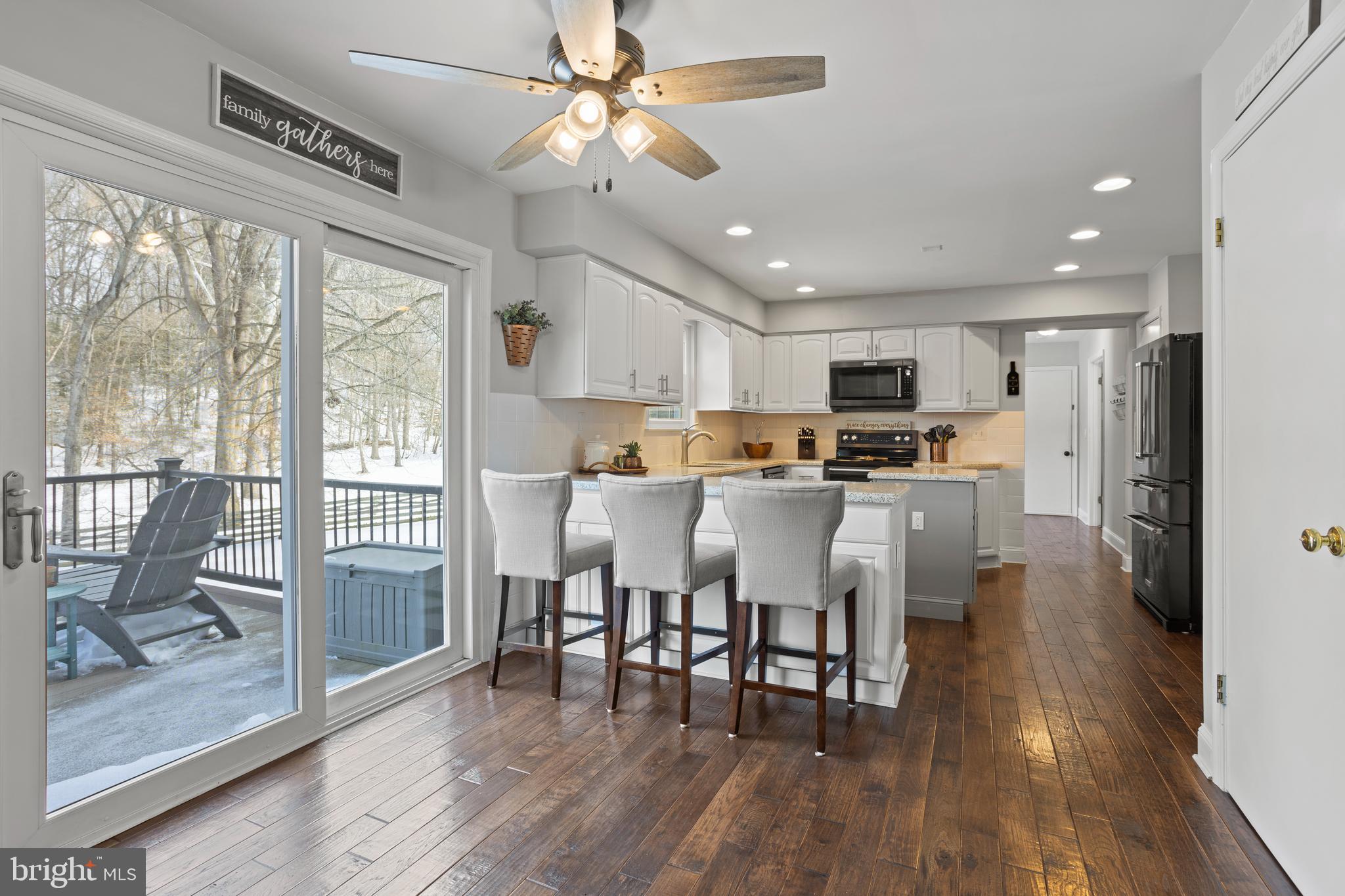 7955 Arbor Way Owings, MD 20736 - Photo 17 of 83 a view of kitchen with stainless steel appliances granite countertop a stove a refrigerator a microwave oven a dining table and chairs with wooden floor