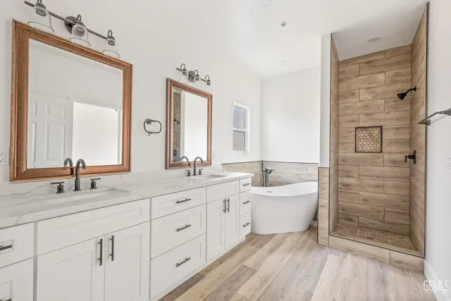 a spacious bathroom with a double vanity sink a mirror and a shower
