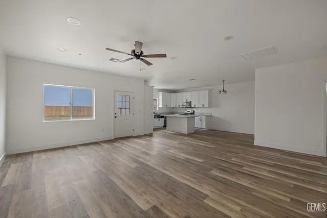 a view of empty room with wooden floor and windows
