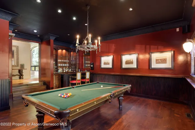 a room with pool table and windows