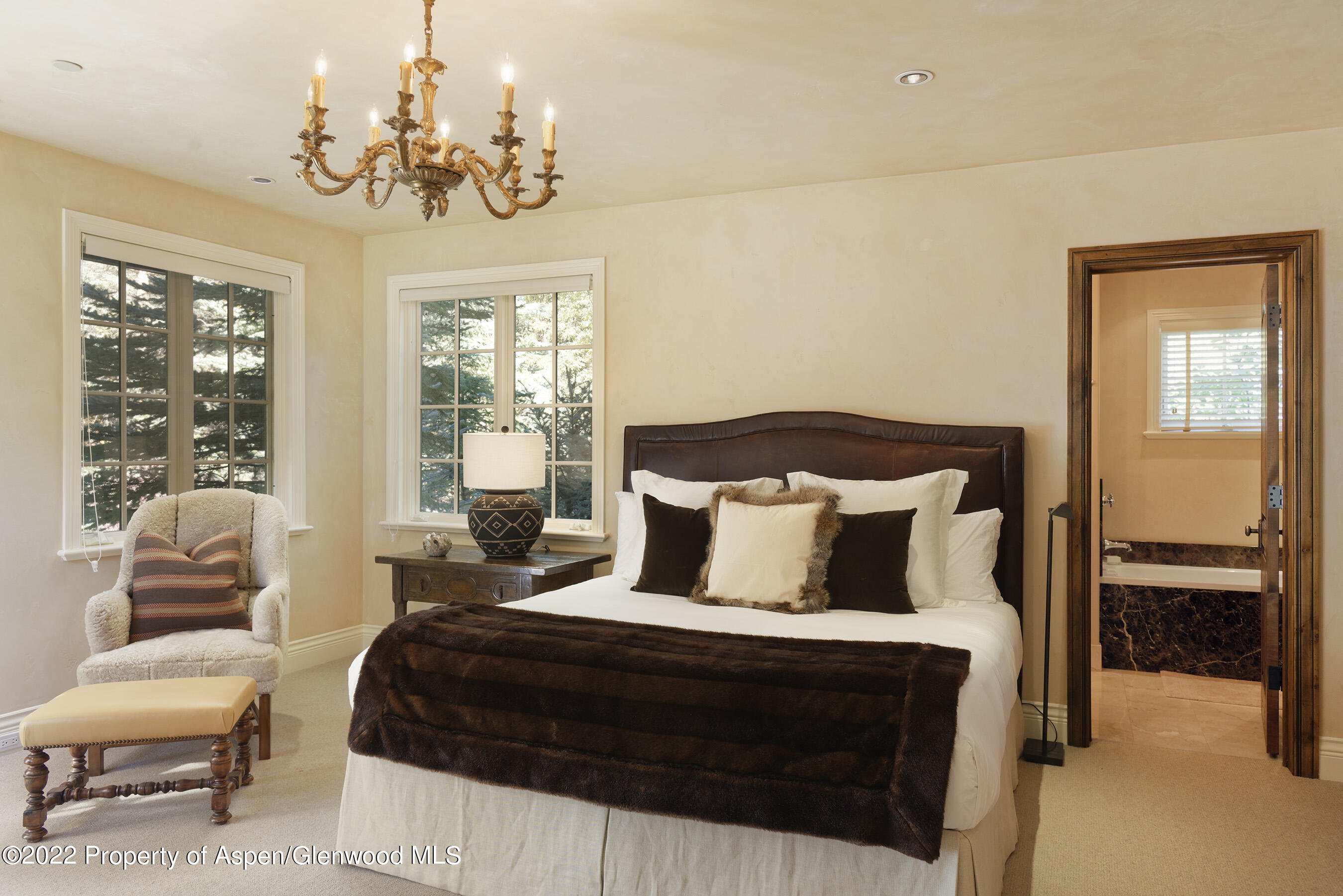 333 Snowmass Creek Road Snowmass, CO 81654 - Photo 14 of 41 a bedroom with a bed a chandelier and a window
