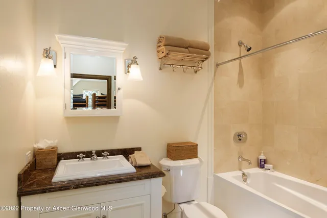 a bathroom with a sink mirror vanity and toilet