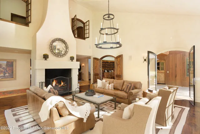 a living room with furniture a fireplace and kitchen view