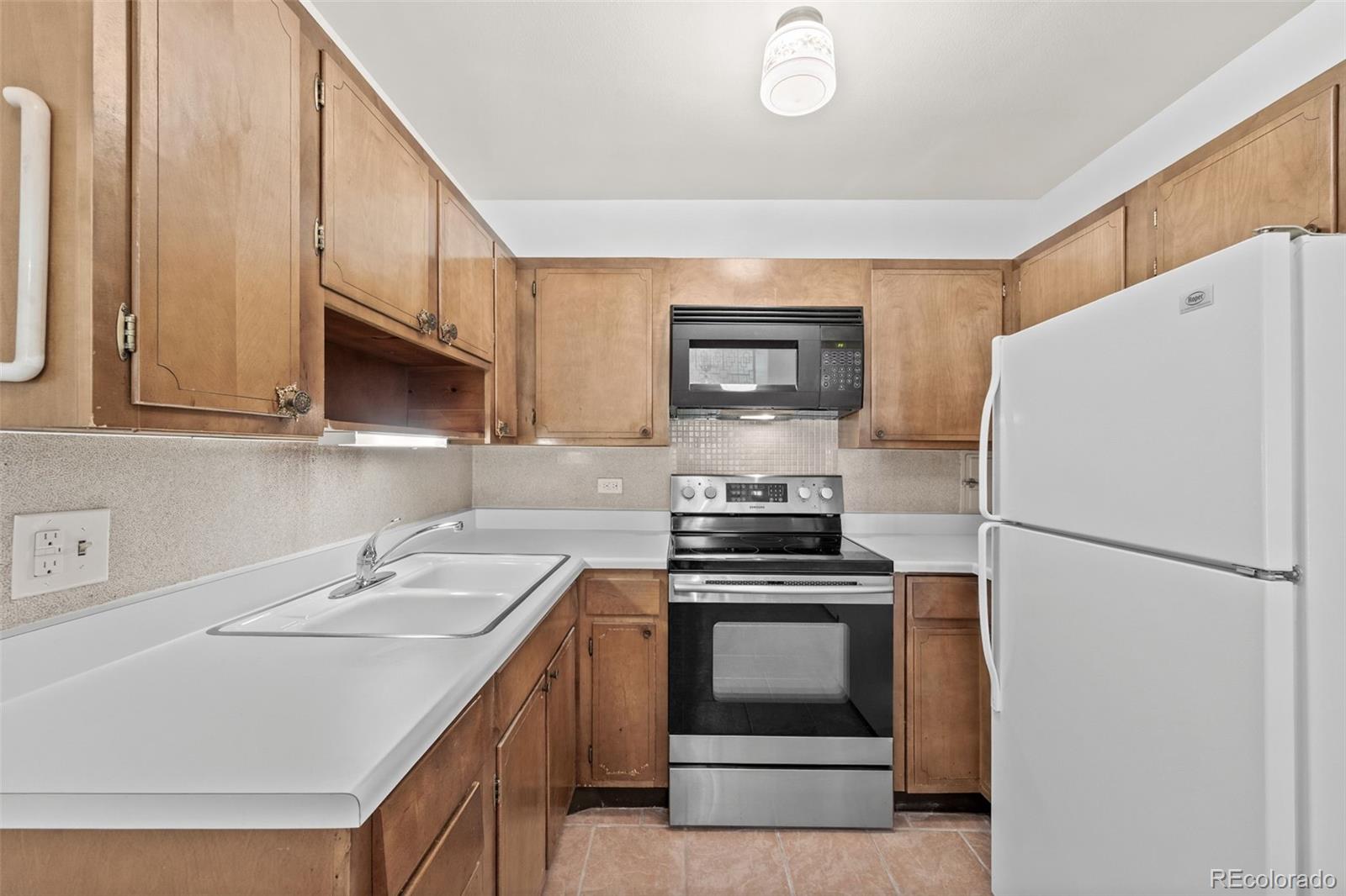 755 South Clinton Street, Unit 7B Denver, CO 80247 - Photo 14 of 36 a kitchen with a sink a stove and refrigerator