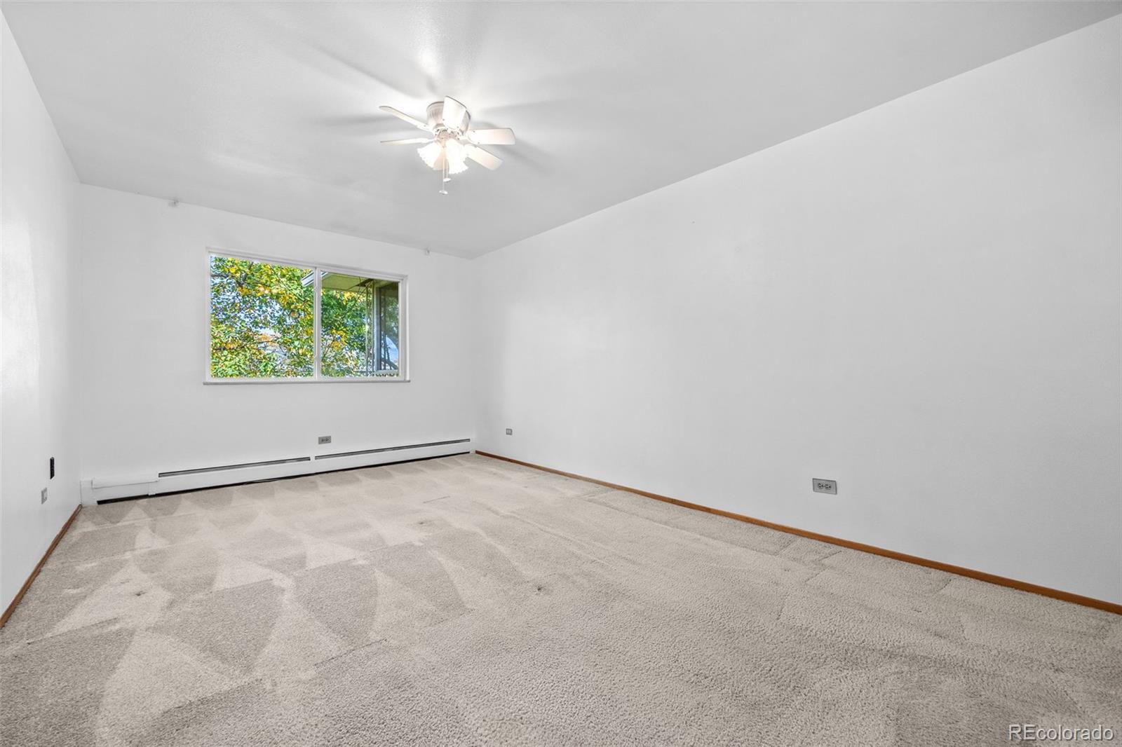 755 South Clinton Street, Unit 7B Denver, CO 80247 - Photo 17 of 36 an empty room with windows and ceiling fan