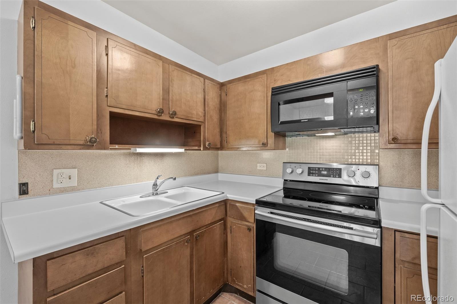 755 South Clinton Street, Unit 7B Denver, CO 80247 - Photo 2 of 36 a kitchen with a sink stove and microwave