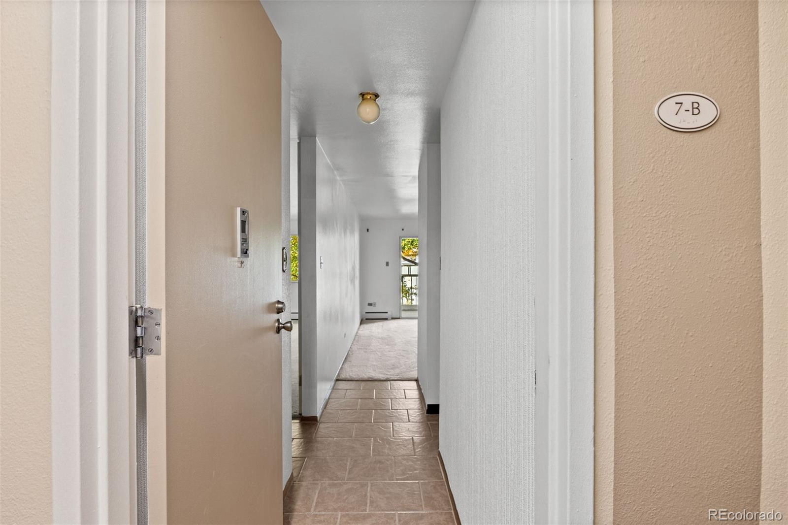 755 South Clinton Street, Unit 7B Denver, CO 80247 - Photo 8 of 36 a view of a livingroom from a hallway