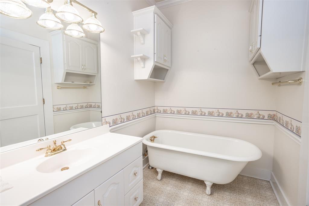 206 Ritchey Street Gainesville, TX 76240 - Photo 22 of 36 a bathroom with a tub sink and mirror
