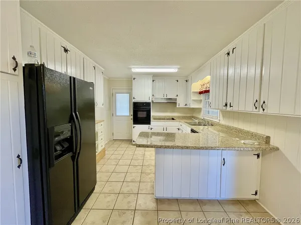 a kitchen with stainless steel appliances granite countertop a refrigerator and a stove