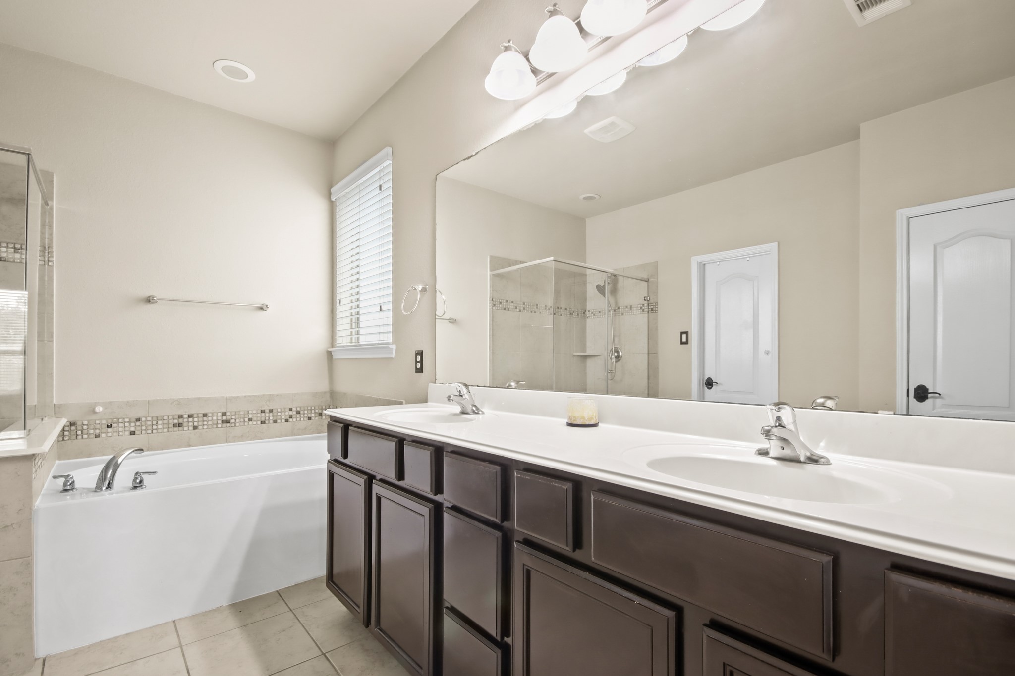 25407 Terrain Park Drive Spring, TX 77373 - Photo 20 of 33 a bathroom with a sink a large mirror and a bathtub