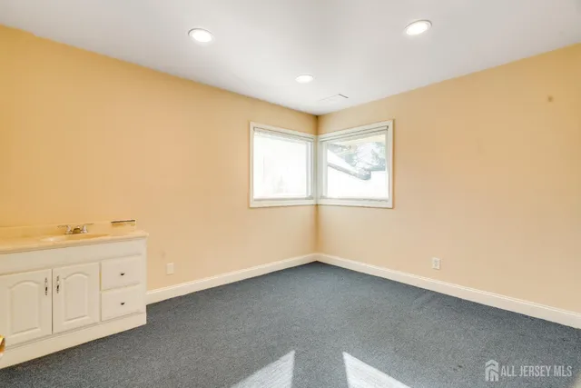 an empty room with wooden floor and window