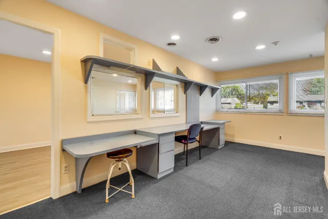 a view of a workspace with furniture and windows