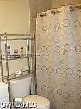 a bathroom with a toilet and a shower curtain