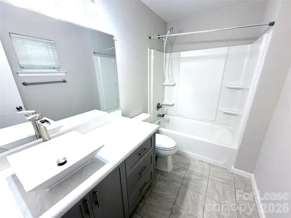 a bathroom with a sink a toilet a mirror and shower