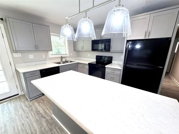 a kitchen with granite countertop a sink stainless steel appliances and cabinets