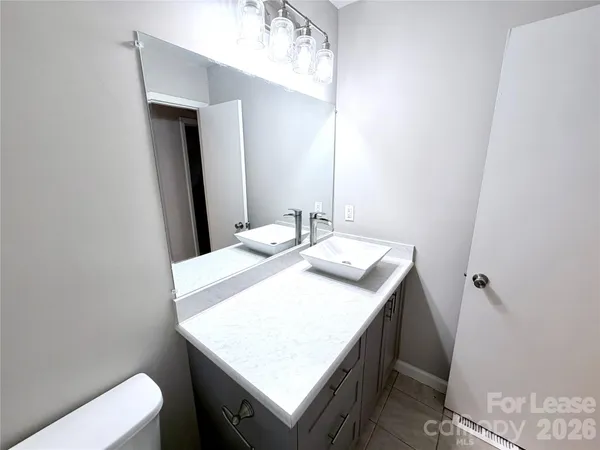 a bathroom with a sink a toilet and a mirror